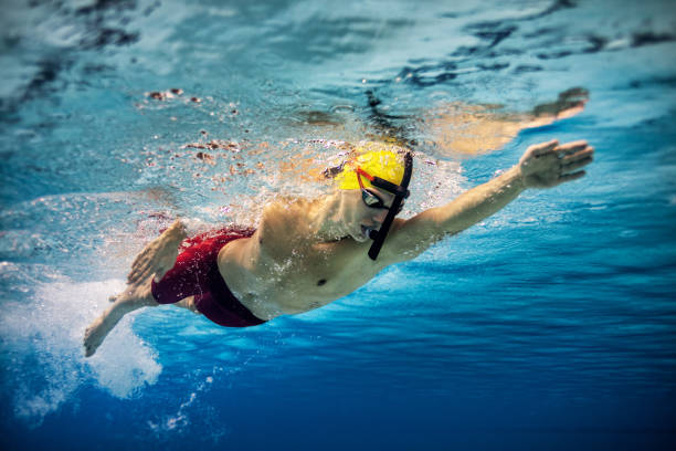 Professional athlete at swimming sport training Underwater shot of young man practicing front crawl style of swimming in the swimming pool. Photo taken from low angle only young men stock pictures, royalty-free photos & images