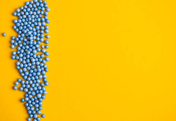 istock Colorful sprinkles in blue on yellow background with copy space for text, party background with blue confetti 1210372487