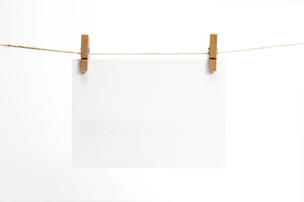 folhas de papel vazias para nota, quadros que ficam pendurados em uma corda com alfinetes e isolados em branco. cartões em branco na corda. modelo de mockup para memórias de pano de fundo, fotos, mídias sociais etc. - adhesive note note pad clothespin reminder - fotografias e filmes do acervo