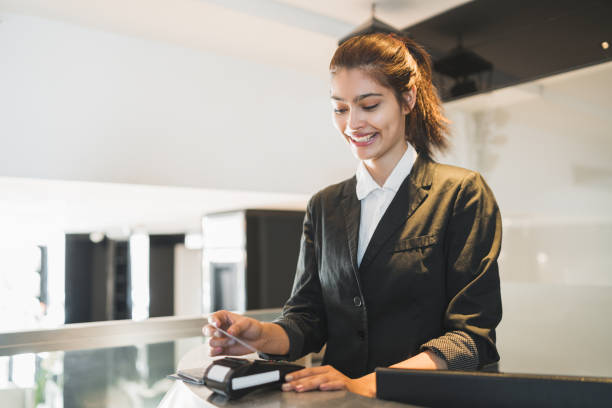 istock Receptionist passing card and charging guest stay at reception. 1210375821
