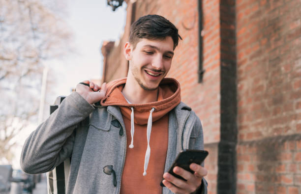 istock Young man using his mobile phone on the street. 1210375829