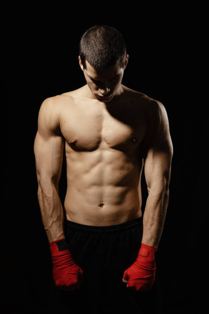 istock Athletic boxer getting ready before the fight over black background 1210375909