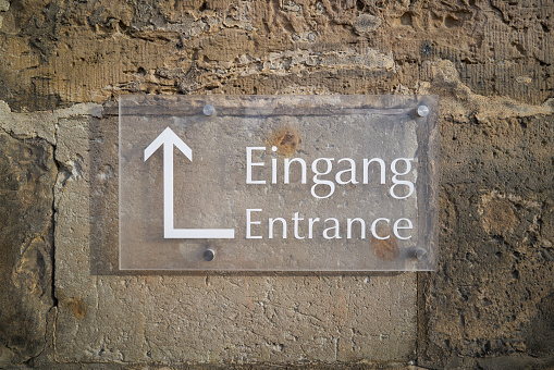 Sign with the inscription Entrance (Eingang) and a directional arrow to the entrance of a church
