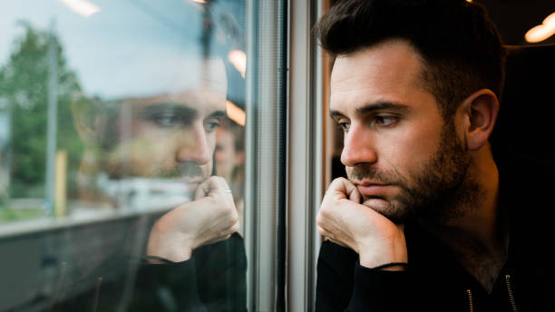 istock Young bearded man traveling by train in late afternoon 1210378287