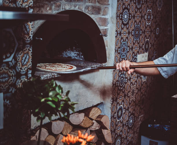 istock Chef is putting pizza to the oven 1210378356