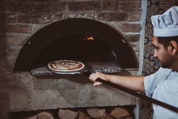 istock Chef is putting pizza to the oven 1210378905