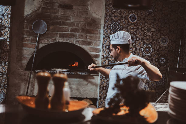 istock Chef is putting pizza to the oven 1210378922