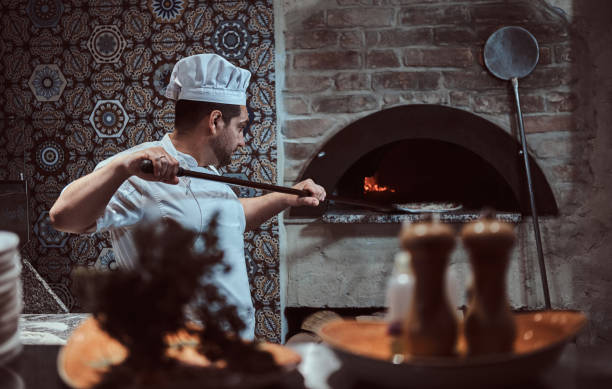 istock Chef is putting pizza to the oven 1210379461