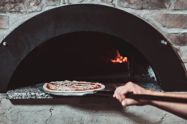 istock Chef put pizza to the oven for baking 1210380610