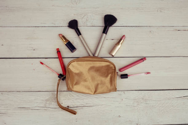 istock Make-up bag with products spilling out on a wooden background 1210380730