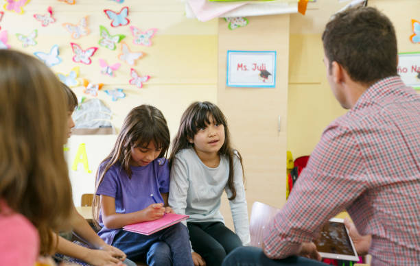 istock Teacher talking with a small group of children at school about values 1210380891