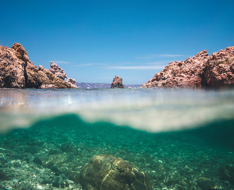 Underwater view on the rocks peeking from the sea (Milos, Cyclades, Greece).