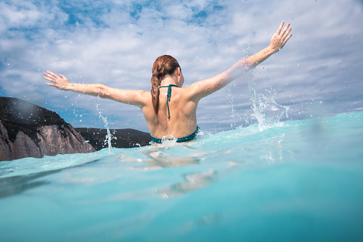 Young woman having fun in beautiful turquoise sea (Keafalonia, Greece).