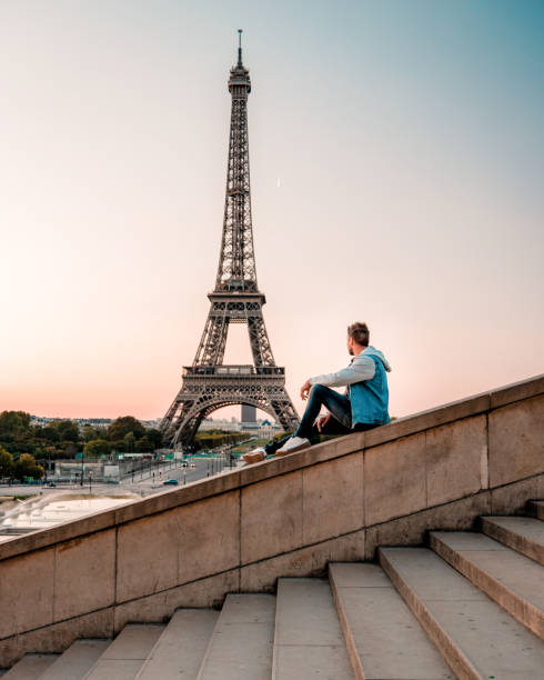 istock young men watching Eiffel tower in Paris. guy tourist visiting Paris France by eiffel tower 1210385626