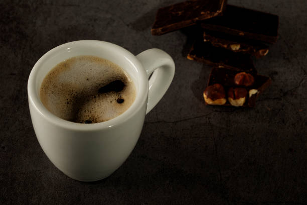 istock Black coffee cup with coffee on a dark background. With copy space for your text. Cup of coffee on a black background low key copy space. 1210387573
