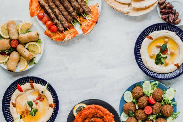 Lebanese food eaten for Ramadan eid with space for text. Middle eastern traditional cuisine including falafel, hummus, halal kebab meat, dates, Muajjanat Sabanej, muhammara and mutabal. A table of middle eastern food with copy space lebanese culture stock pictures, royalty-free photos & images