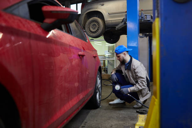 istock Repairman Using Tire Pressure Gage 1210389174