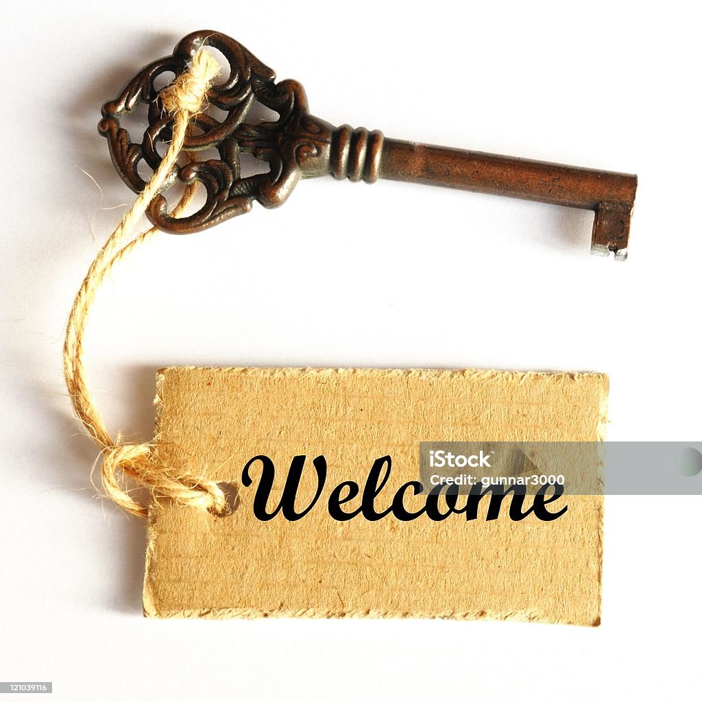 Old key with welcome stamped in the keychain welcome concept with old grunge key and label or tag Color Image Stock Photo