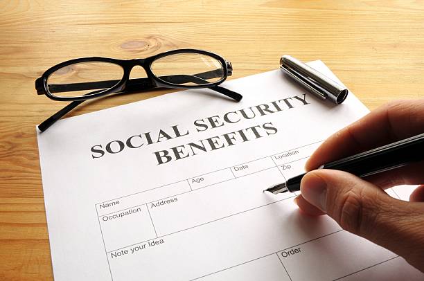 istock Hand filling out Social Security benefits paperwork 121039271