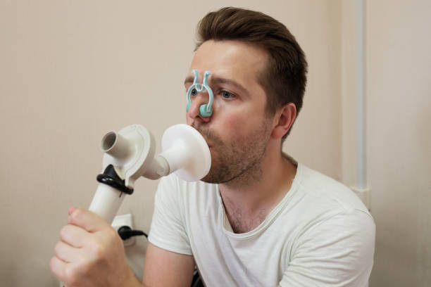 Young man testing breathing function by spirometry stock photo