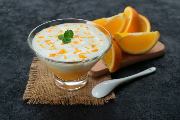 istock Yogurt with orange  on a black background. 1210400709