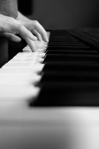 Close up shot of a little girl playing the piano, black and white concept.