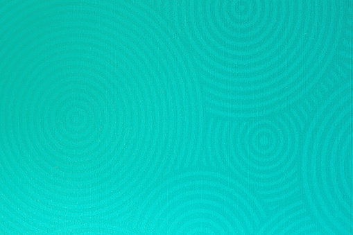 Texture of stucco wall close-up, with embossed twirl curve, spiral, mint color. Modern trendy background, for banner design