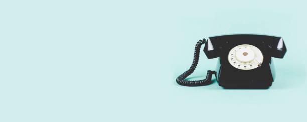 istock Old black phone on green background. Copy space for text or design 1210405232