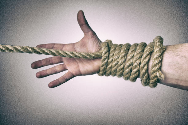 istock Man's hand tied with a rope, vintage effect photo 1210407616