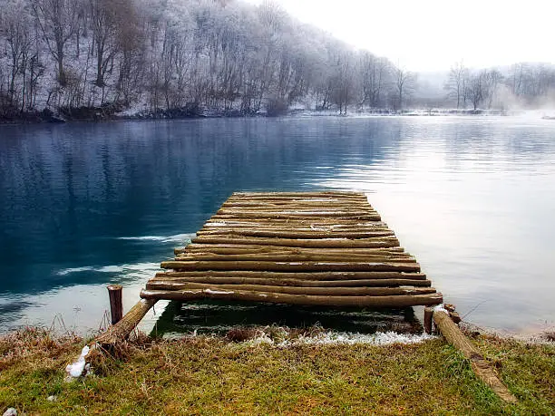 Wooden pier on the mountain river in winter morning