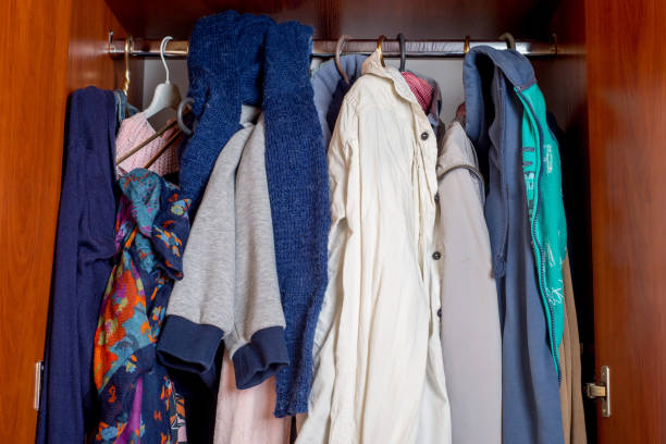 istock open wardrobe with clothes on hangers and clutter in open drawers 1210414077