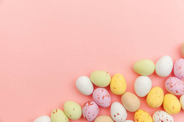 istock Happy Easter concept. Preparation for holiday. Easter candy chocolate eggs and jellybean sweets isolated on trendy pastel pink background. Simple minimalism flat lay top view copy space 1210414995
