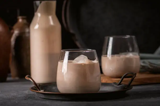 Irish cream coffee liqueur with ice on dark background