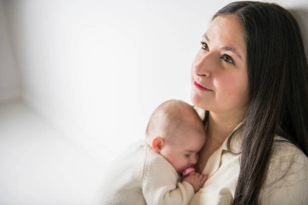istock Young mother with his daughter sit on a white floor studio, trying to consoling 1210416974
