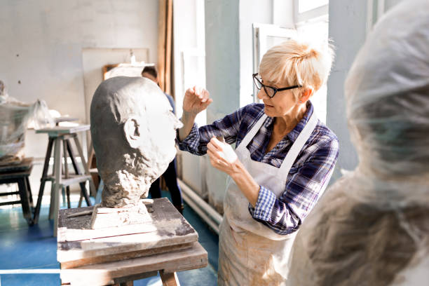 istock Teacher Senior woman making statue of clay in studio workshop 1210417837