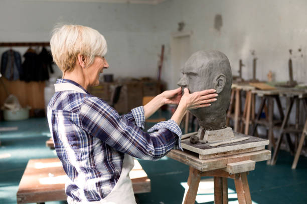 istock Senior woman making head statue of clay in studio workshop 1210417937