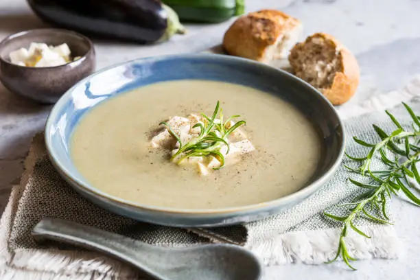 Creamy Eggplant and zucchini soup with Balkan cheese on a ceramic plate