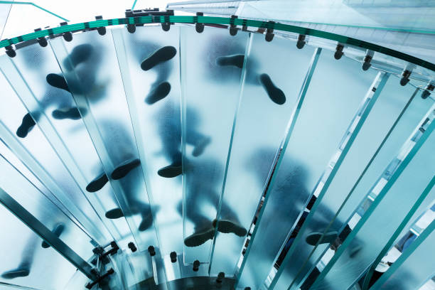 istock Feet On Glass Spiral Stairs 1210420199