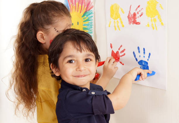 little girl and boy are doing paint - child art childs drawing painted image imagens e fotografias de stock