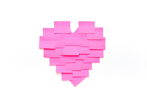 Blank Pink Sticky Notes Sticked On White Wall In Heart Shape Stock