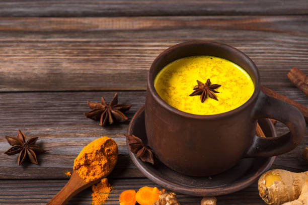 istock Golden milk or turmeric latte made with curcuma, star anise, ginger and cinnamon on rustic wooden table. Healthy drink 1210420904