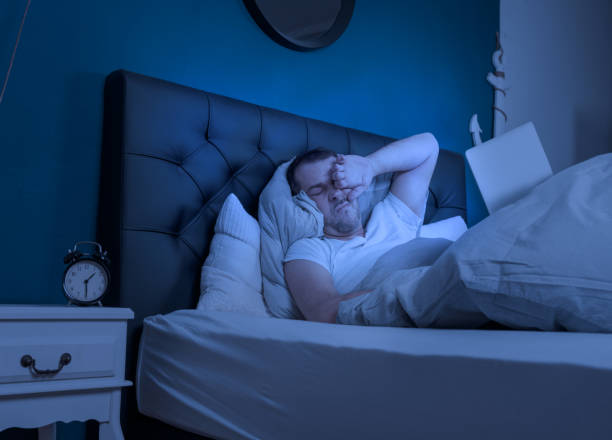 istock an overtired man works at night on his laptop 1210423541