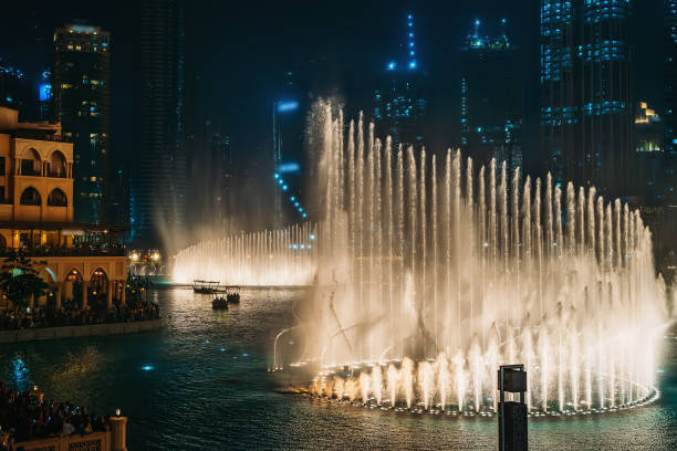 дубайский фонтан с освещением ночью. популярное туристическое место в центре города, оаэ - dancing fountains стоковые фото и изображения