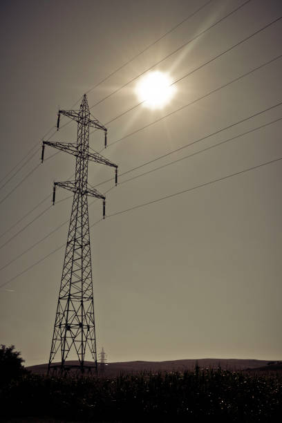 Sun shining above high voltage power lines on power pylons