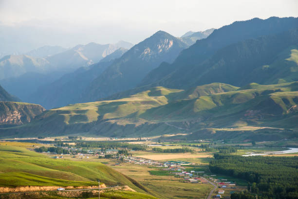 istock Peaceful village in valley with forest and river 1210429505