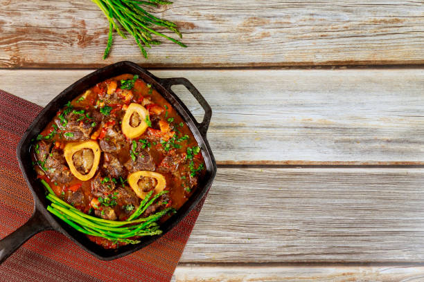 guisado de carne feita de osso de pernil em, vegetais e aspargos. - veal meat osso buco beef stew - fotografias e filmes do acervo