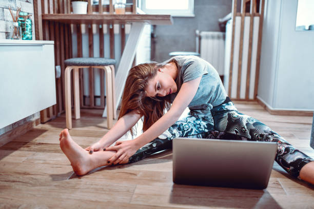 istock Cute Female Stretching And Watching Exercises On Laptop 1210433295