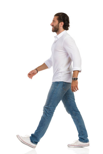 istock Walking Man In White Shirt, Jeans And Sneakers. Side View. 1210441719