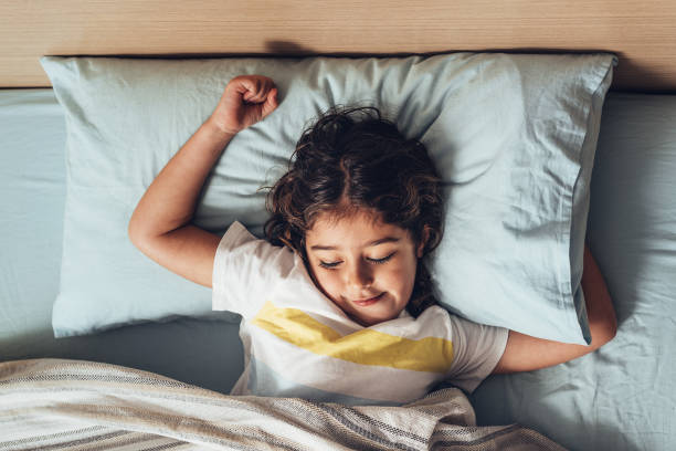 istock kid stretching out in bed when she just woke up 1210441776