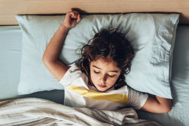 istock kid sleeping in bed at morning about to wake up 1210441777